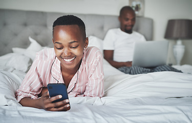 Image showing Black woman with smartphone, relax in bed with technology and online communication, website and wifi. Man with laptop, couple happy at home with tech, social media and internet connectivity with app