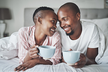 Image showing Coffee, bedroom and morning with a black couple together on a bed in their home to relax on the weekend. Love, tea or early with a happy young man and woman relaxing while bonding in their house