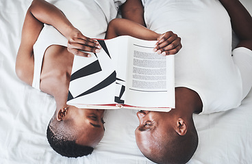 Image showing Book, reading and overhead with a black couple in bed, lying together in the morning in their home. Read, books or love with a man and woman bonding in the bedroom of their house from above