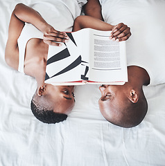 Image showing Books, reading and overhead with a black couple in bed, lying together in the morning in their home. Read, book or love with a man and woman bonding in the bedroom of their house from above