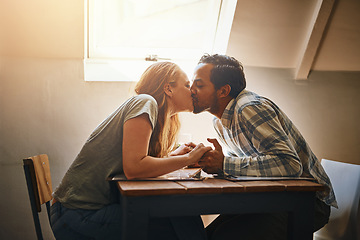 Image showing Couple, love kiss and holding hands at restaurant, intimacy or bonding together at table. Valentines day, romance diversity and affection, kissing and care of man and woman enjoying date time at cafe