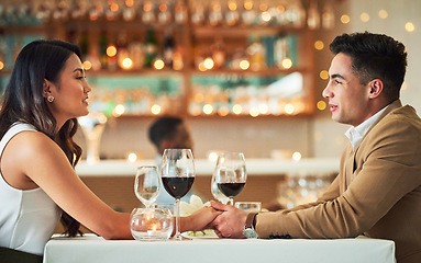 Image showing Couple holding hands, romantic date in restaurant, celebrate Valentines day holiday with love and fine dining together. Commitment, interracial relationship and man with woman, trust and support