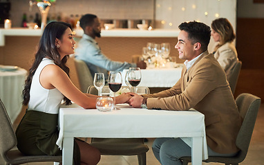 Image showing Couple in restaurant for dinner, holding hands and romantic date on Valentines day, love and celebrate holiday. Commitment, interracial relationship and man with woman, trust, support and celebration