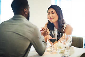 Image showing Couple, holding hands and wine in restaurant with talking, love and romance for valentines day date in night. Black man, asian woman and conversation for bonding, luxury fine dining and celebration