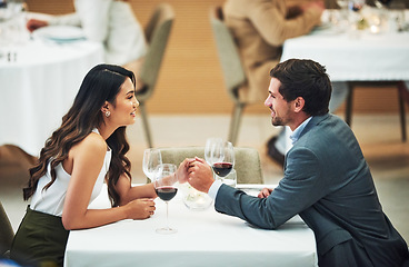 Image showing Restaurant, date and couple holding hands with wine for romantic dinner, relax and anniversary celebration. Relationship, fine dining and man and woman enjoying luxury drinks, alcohol and valentines