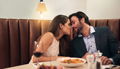 Image showing Happy couple, sharing food and kiss for dinner date, embrace or relationship romance at night in restaurant. Man and woman lean with noodle mouth for intimate kissing in fine dining on valentines day