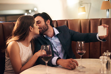 Image showing Kiss, selfie and romantic couple fine dining at a luxury restaurant with love, care and happiness together. Lovers, people and man taking a picture with his woman on valentines day for social media