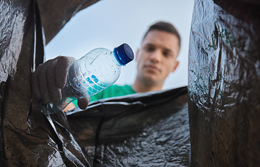 Image showing Recycle, bottle and man with view in bag, sustainability and cleaning plastic pollution for earth day and help with community. Saving the environment, charity and people putting trash in garbage bin.