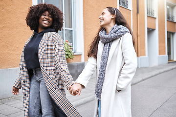 Image showing Woman, friends and holding hands with smile in the city for friendship, travel or laughing for fun journey together. Happy women walking, touching hand and smiling for funny outdoor traveling in town