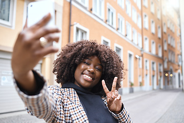 Image showing Selfie, peace hand sign and black woman in a city on travel with a phone and happiness outdoor. Urban street, vacation and smile of a young person on social media for holiday traveling feeling relax