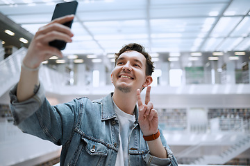 Image showing Selfie, university and man student with peace sign for social media update, blog post or live streaming his experience. Education, research and person in campus library with smile for profile picture