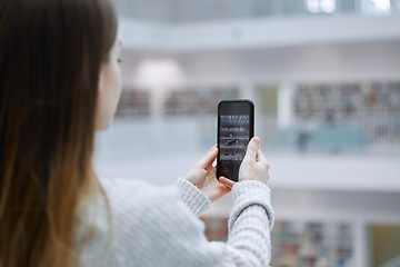 Image showing Phone, photography and student in library for research update, social media post or content creation at university. Influencer woman or person with smartphone screen for live streaming campus design