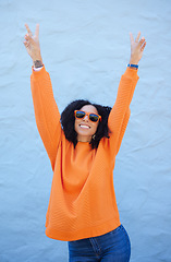 Image showing Carefree, peace sign and trendy woman on a wall in the city for cool energy, playful and happy with sunglasses. Comic, fun and crazy stylish girl with a hand emoji for freedom and funky smile