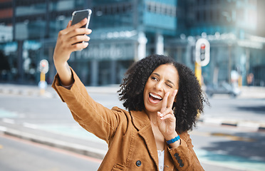 Image showing Selfie, peace sign and funny woman in city for travel fun, vacation and social media update. Comic, smile and goofy influencer in the street with a hand emoji live streaming on a mobile in France