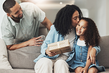 Image showing Birthday, kiss and child with gift from parents to celebrate a special occasion, achievement or event. Affection, gratitude and mom kissing a child while giving a present from dad for celebration