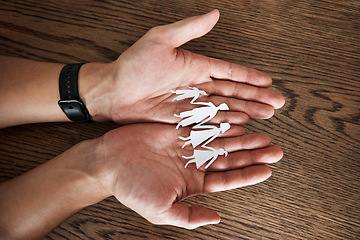 Image showing Hands, paper cutout family and home on table for sign, symbol or icon of support, love or solidarity. Art design with mother, father and kids holding hands for trust, care or together in community