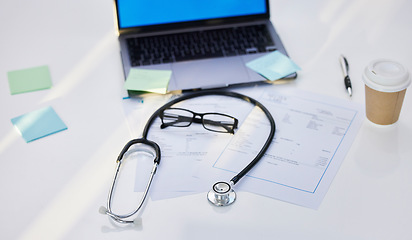 Image showing Laptop, stethoscope and medical paperwork in a office for research, diagnosis or test results. Sticky notes, coffee and glasses on a desk for doctor to read healthcare documents in hospital or clinic