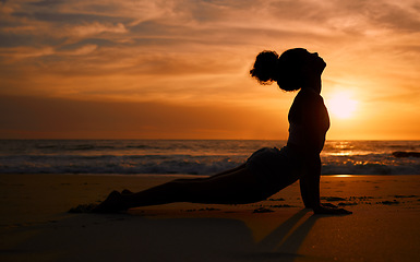 Image showing Sunset yoga, fitness and silhouette of a woman at the beach for mindfulness training at night. Meditation, zen and girl stretching for a pilates pose at the sea in the evening for spiritual exercise