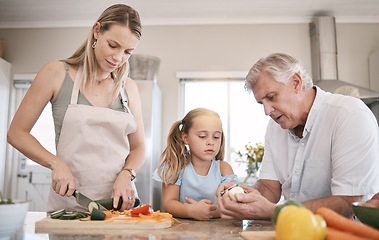 Image showing Family home, cooking a vegetables with a child helping mother and grandfather in the kitchen. Woman, man and girl kid learning to make lunch or dinner with love, care and bonding over food together