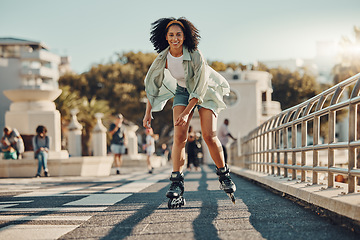 Image showing Exercise, city and black woman roller skating for fitness, health and wellness outdoors. Sports practice, training and portrait of happy female skater in street, having fun and enjoying exercising.