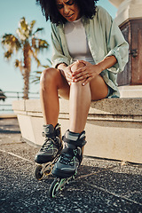 Image showing Knee pain, roller skater injury and woman in city after accident or fall outdoors. Sports, training and black female with fibromyalgia, inflammation or painful leg after skating practice on street.