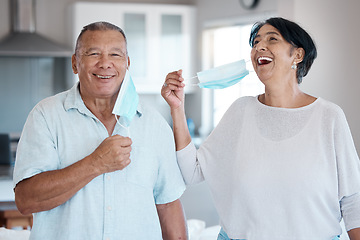 Image showing Covid, mask remove and senior couple portrait with a smile at home in a kitchen. Happy man, mature and marriage of a grandparents in a house laughing with love and care in a household to relax