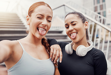 Image showing Women, friends selfie and tongue in city for training, comic time or funny face with headphones in profile picture. Woman workout group, exercise photo or social media by stairs in metro with support