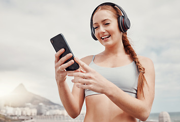 Image showing Headphones, phone and woman doing workout in the city while listening to music, podcast or radio. Fitness, wellness and female athlete networking on social media with cellphone after outdoor exercise