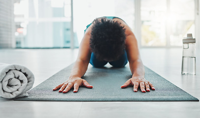 Image showing Yoga, stretching and fitness of a black woman in a gym for zen, relax and chakra exercise. Pilates, peace and meditation training of an athlete in prayer pose on the floor feeling calm from stretch