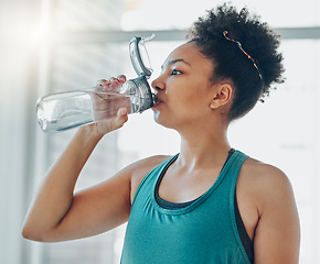 Image showing Drinking water, black woman and fitness of a athlete in a gym after workout and sport. Hydration, drink and healthy young person in a wellness and health center with bottle for training and exercise