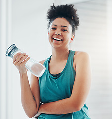 Image showing Portrait, fitness and water with a sports black woman staying hydrated during her cardio or endurance workout. Exercise, training and wellness with a female athlete holding a bottle for hydration