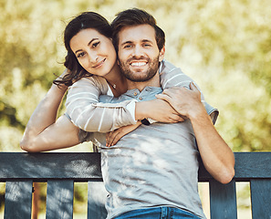 Image showing Love, couple and hug on park bench, portrait and having fun time together outdoors. Valentines day, romance relax and care of man and woman hugging, embrace and cuddle on romantic date and smile.