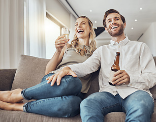 Image showing Couple relax with alcohol drink, watching tv and funny with quality time together in living room with love and commitment. Happy people, comedy entertainment and laughter with happiness at home