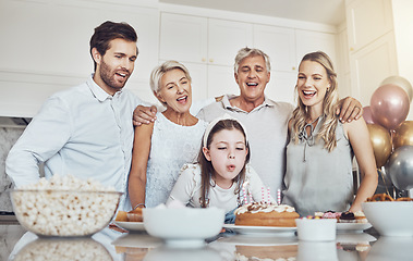 Image showing Birthday, cake and big family with girl blowing out candles for wish, party or celebration event. Love, food and kid with happy father, mother and grandparents celebrating special day in home kitchen