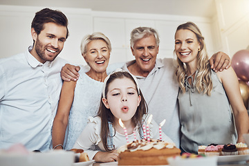 Image showing Cake, birthday and big family with girl blowing out candles for wish, party or celebration event. Love, food and kid with happy father, mother and grandparents celebrating special day in home kitchen