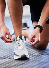 Image showing Shoes, runner and man getting ready for training, exercise or running in sports sneakers, fashion and foot on floor. Feet of athlete or person tying his laces for cardio, fitness or workout in gym