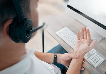 Image showing Pain, overworked and injured call center agent with hurt hand in the office suffering due to strain. Consultant, worker or employee with physical burnout or problem in the workplace with insurance