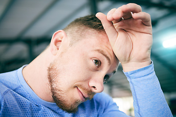 Image showing Exercise, sweat and tired man at gym for training, cardio or intense workout on blurred background. Fitness, break and sweating athletic male stop to breath during exercising routine at sports center