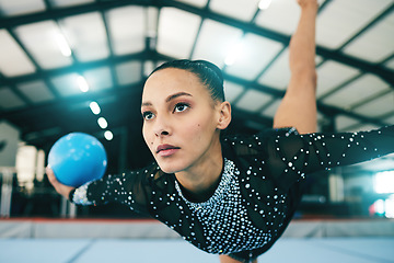 Image showing Woman, gymnastics and stretching in balance with ball for training or practice at the indoor gym. Athletic female professional gymnast or acrobat in warm up stretch for exercise, workout or fitness