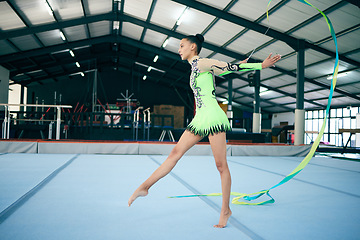 Image showing Rhythmic gymnastics, fitness and woman in gym with ribbon, sport and graceful athlete on mat. Dance, girl gymnast and flexibility with pose and sports, mockup space with training or performance