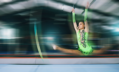 Image showing Gymnastics, fitness and woman with jump and motion blur, sport in gym or arena with action and speed. Athlete, moving and mockup space with gymnast, flexibility and pose with sports and splits in air