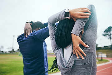 Image showing Fitness, back and black couple stretching arms outdoors for health and wellness at track. Winter sports, training and man and woman warm up, prepare or get ready to start exercise, workout or running