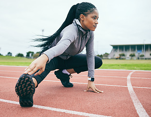 Image showing Fitness, exercise and black woman stretching legs for health and wellness at stadium outdoors. Winter sports, training runner and female prepare and get ready to start workout, running or exercising.