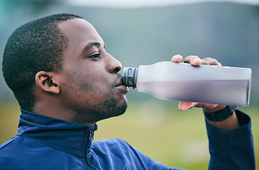 Image showing Fitness, health and side profile of black man drinking water to hydrate after running, exercise and workout. Healthy, sports and African athlete with a drink after training and cardio in Germany