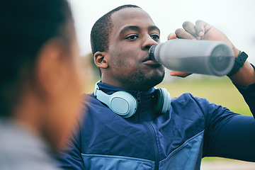 Image showing Break, fitness and black man drinking water after a race, training and sports at a stadium in Morocco. Health, relax and African athlete with a drink to hydrate after a workout, running and exercise