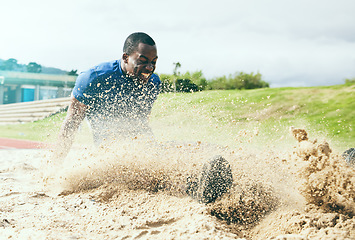 Image showing Long jump, fitness and black man in the sand for sports, exercise and competition in the USA. Energy, speed and African athlete training for a sport challenge, jumping and landing with power