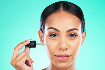 Image showing Beauty, portrait and oil by woman in studio in skincare, wellness or cosmetic on blue background. Face, serum and girl with facial product for skin, anti aging or collagen, retinol or hyaluronic acid