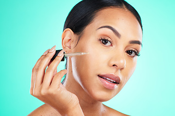 Image showing Skincare, oil and portrait of woman in studio for beauty, wellness or cosmetic on blue background. Face, serum and girl for facial product for skin, anti aging or collagen, retinol or hyaluronic acid