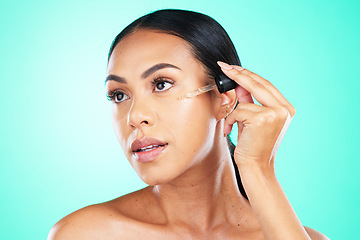 Image showing Skincare, oil and black woman in studio for beauty, wellness or cosmetics on blue background. Face, serum and girl with facial product for skin, anti aging or collagen, retinol or hyaluronic acid