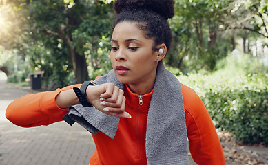 Image showing Woman checking her pulse with a smart watch while on a health, fitness and wellness run in nature. Active girl on a jog for a cardio exercise in an outdoor park with an activity tracker and towel.